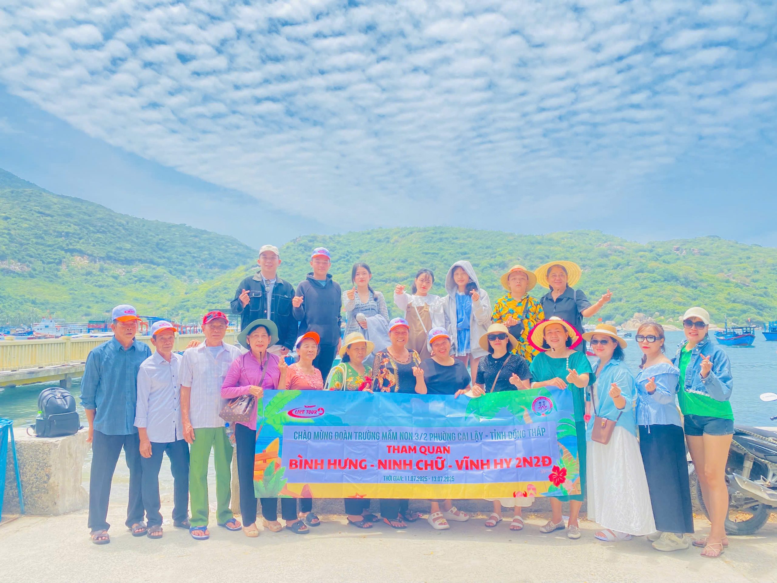 Đoàn khách tham gia tour đoàn Ninh Chữ Vĩnh Hy check-in kỷ niệm bên bờ biển xanh ngắt.