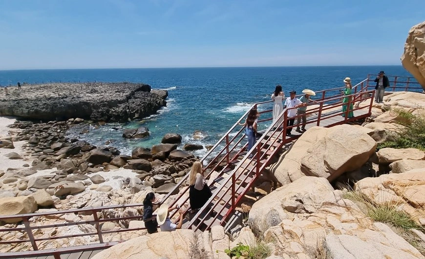Du khách check-in trên cầu gỗ tại Hang Rái Ninh Thuận trong hành trình tour khách đoàn của Like Tour.